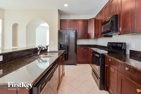 a large kitchen with granite counter tops and wooden cabinets