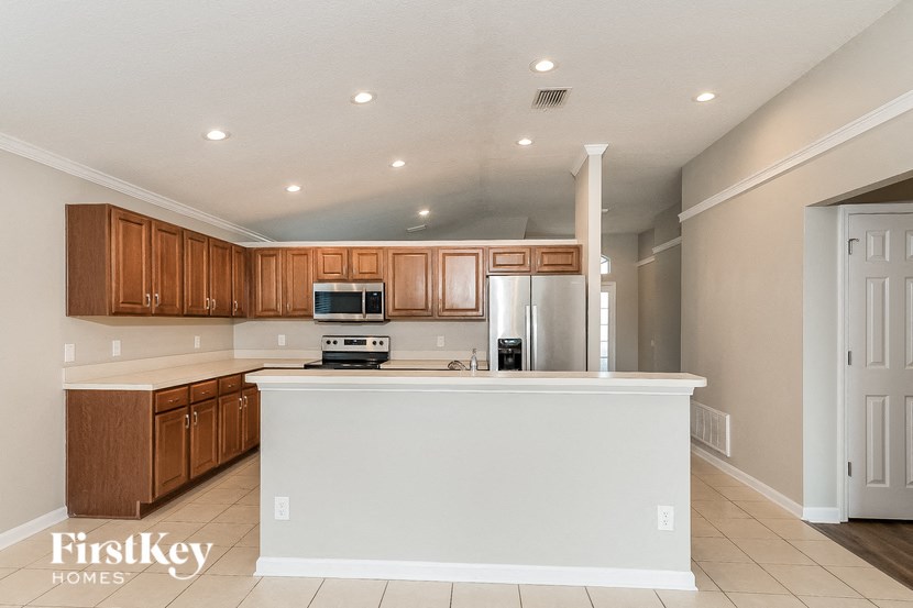 a kitchen with a white counter top and wooden cabinets