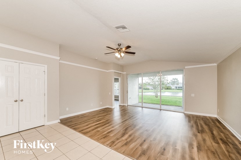 an empty living room with a ceiling fan
