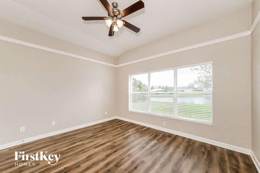 the living room has a large window and a ceiling fan