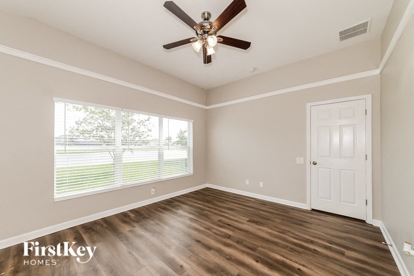 an empty room with a ceiling fan and a window