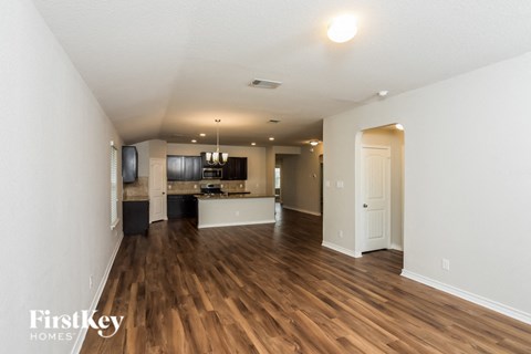 A spacious room with wooden floors and a white door.