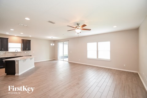 A spacious room with wooden flooring and a ceiling fan.