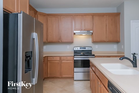 A kitchen with wooden cabinets and a stainless steel refrigerator.