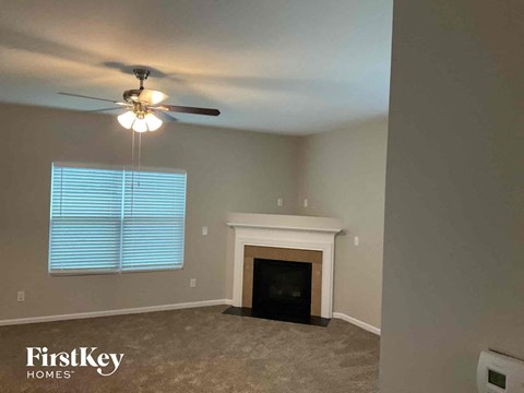 a living room with a fireplace and a ceiling fan