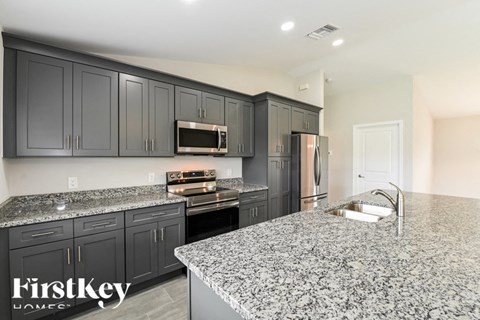 a kitchen with granite counter tops and black cabinets