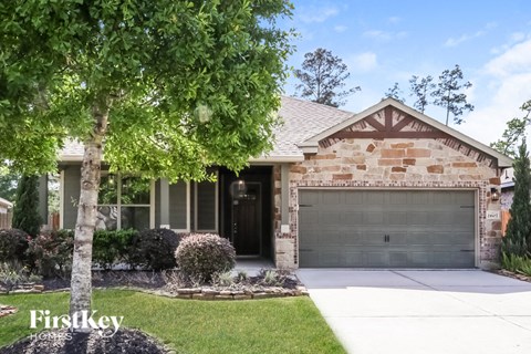 a house with a garage door in front of a tree