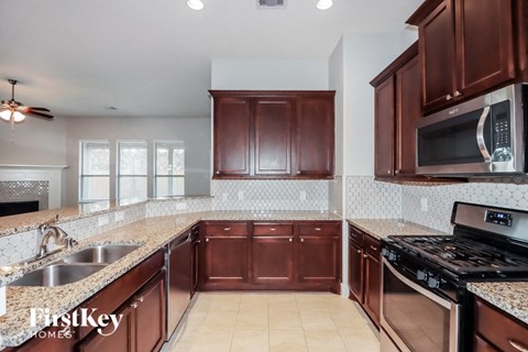 a kitchen with wooden cabinets and granite counter tops and a stove and sink