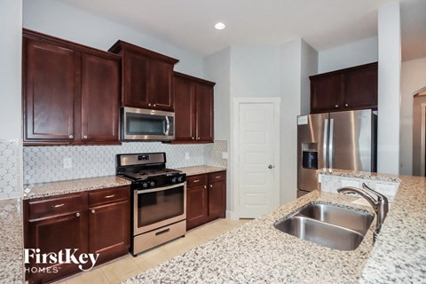 a kitchen with granite counter tops and wooden cabinets
