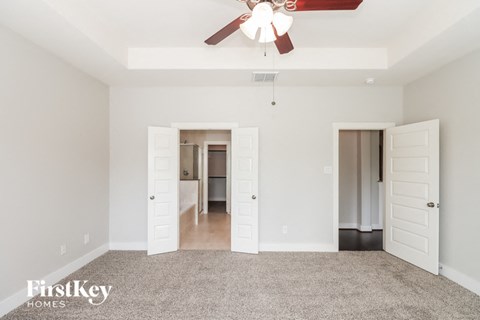 a living room with carpet and a ceiling fan