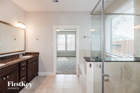 a bathroom with a shower and a sink and a mirror