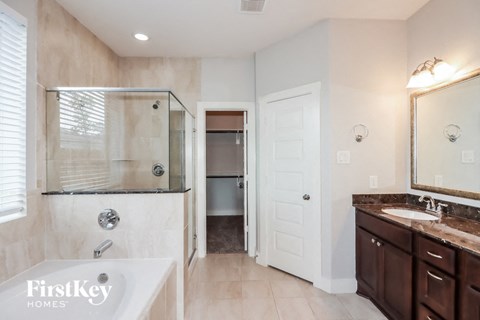 a bathroom with a tub and a shower and a sink