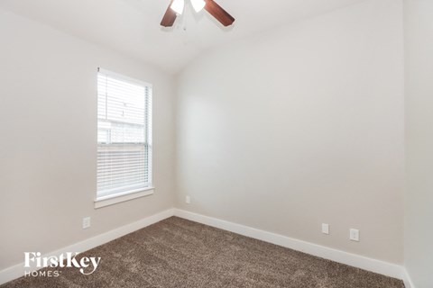 a bedroom with a carpeted floor and a window