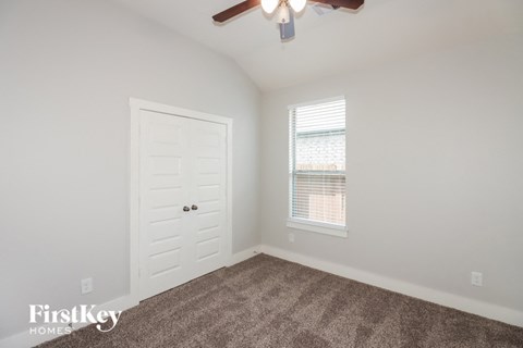 a bedroom with a white door and a ceiling fan