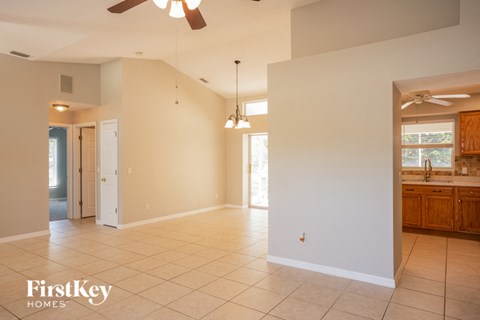 an empty kitchen and living room with a ceiling fan