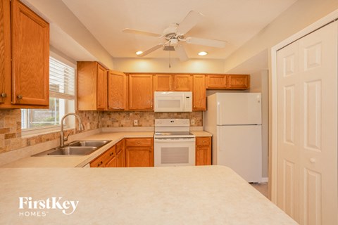 a kitchen with white appliances and wooden cabinets