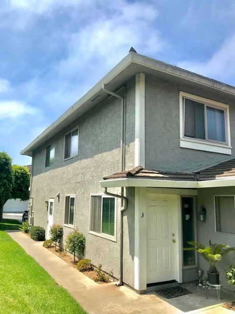 A grey house with a white door and windows.