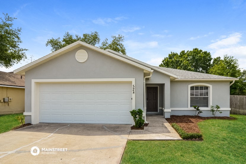 a white house with a white garage door and a lawn