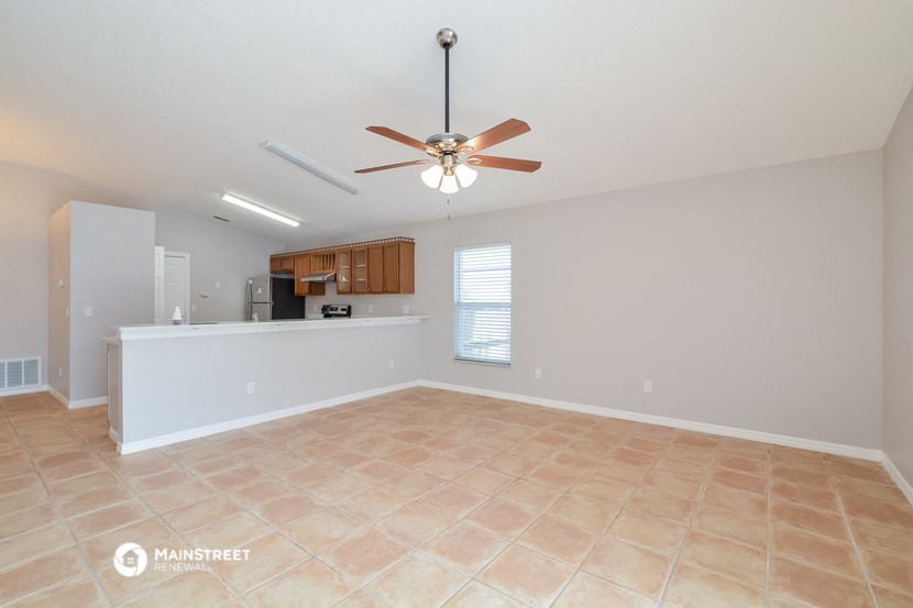 the living room and kitchen are spacious with tile floors and a ceiling fan