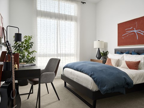Bedroom with Desk and Personal Touches Bedroom at Kaia South Bay with bed, guitar, and desk setup - ideal for work and relaxation