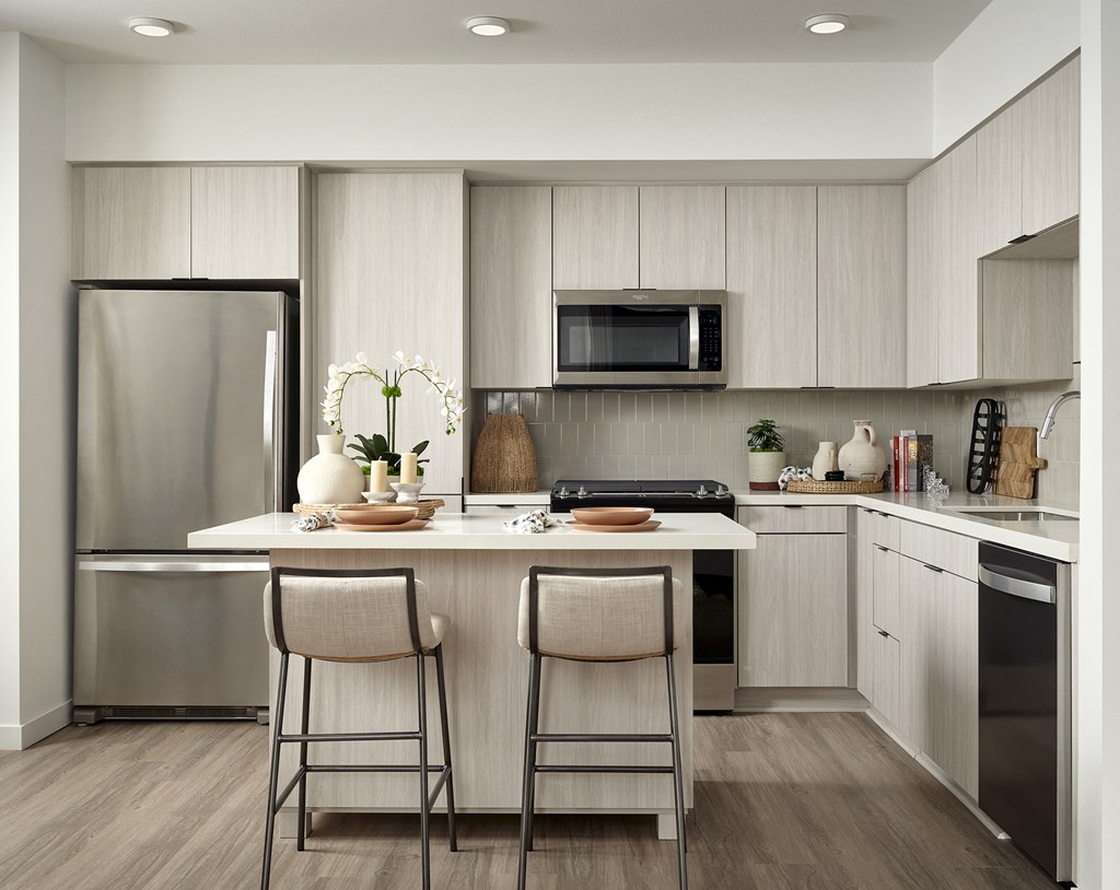 a kitchen with stainless steel appliances and a island with two stools