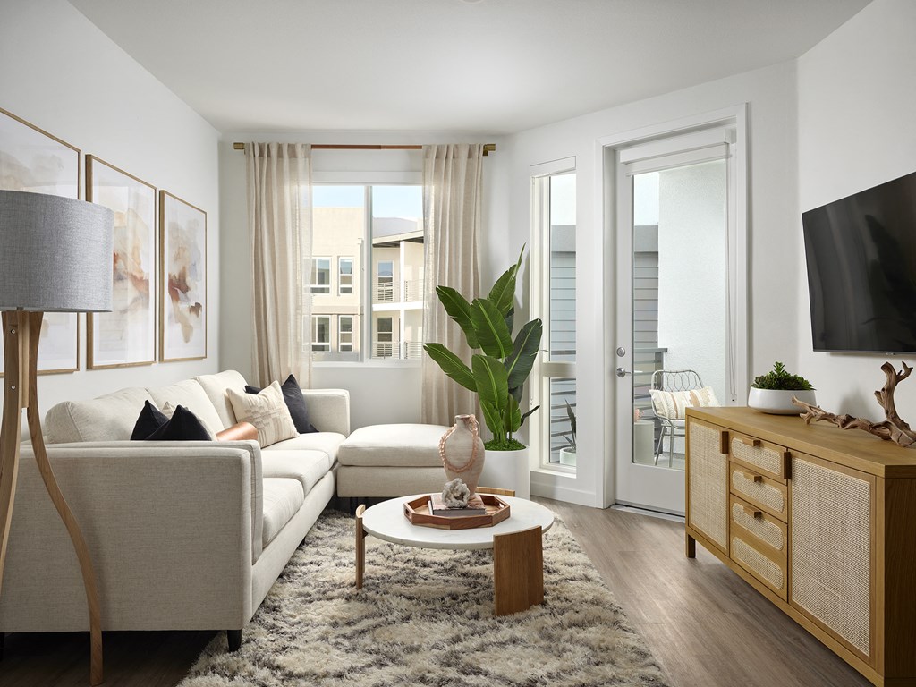 a living room with a couch and a table   and a balcony