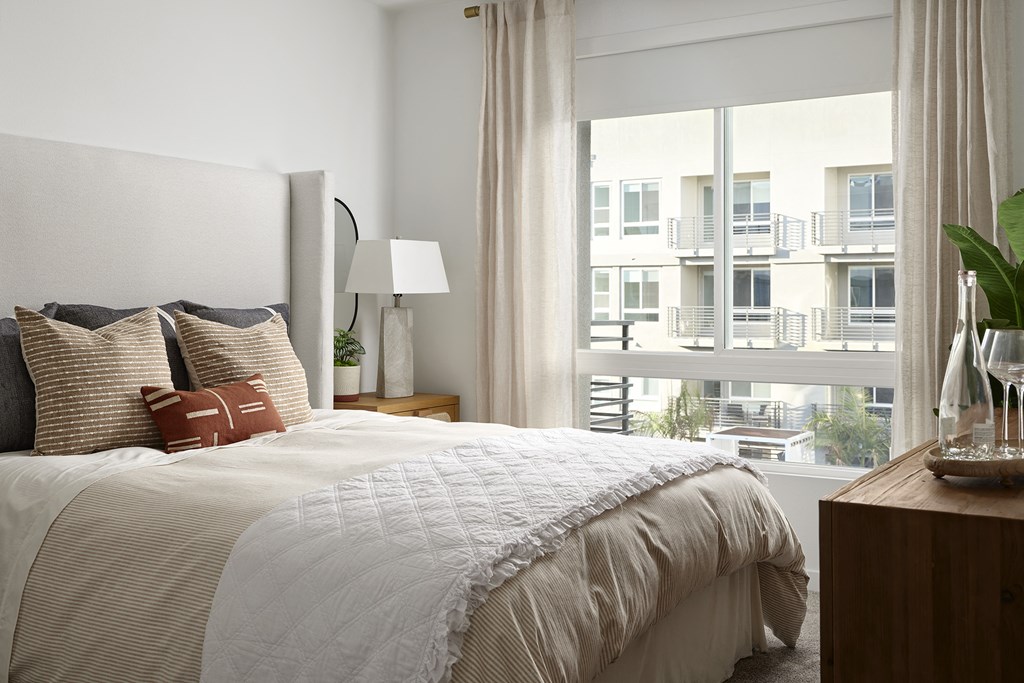 a bedroom with a bed and a large window