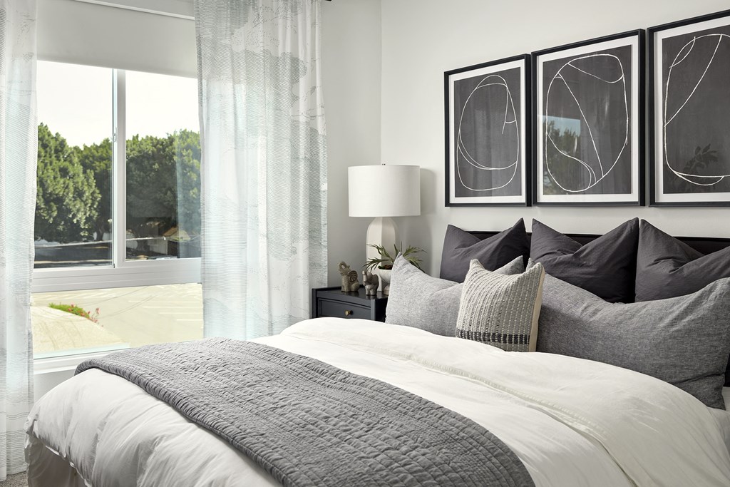 a bedroom with a bed and three pictures on the wall