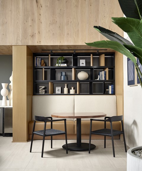 Dining Area with Bookshelf at Kaia Dining area at Kaia South Bay with table, chairs, and built-in bookshelf