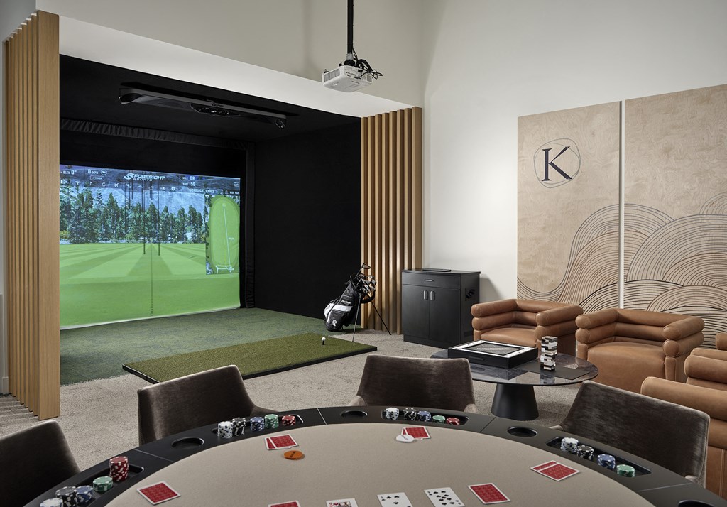 a room with a poker table and a video game on the wall
