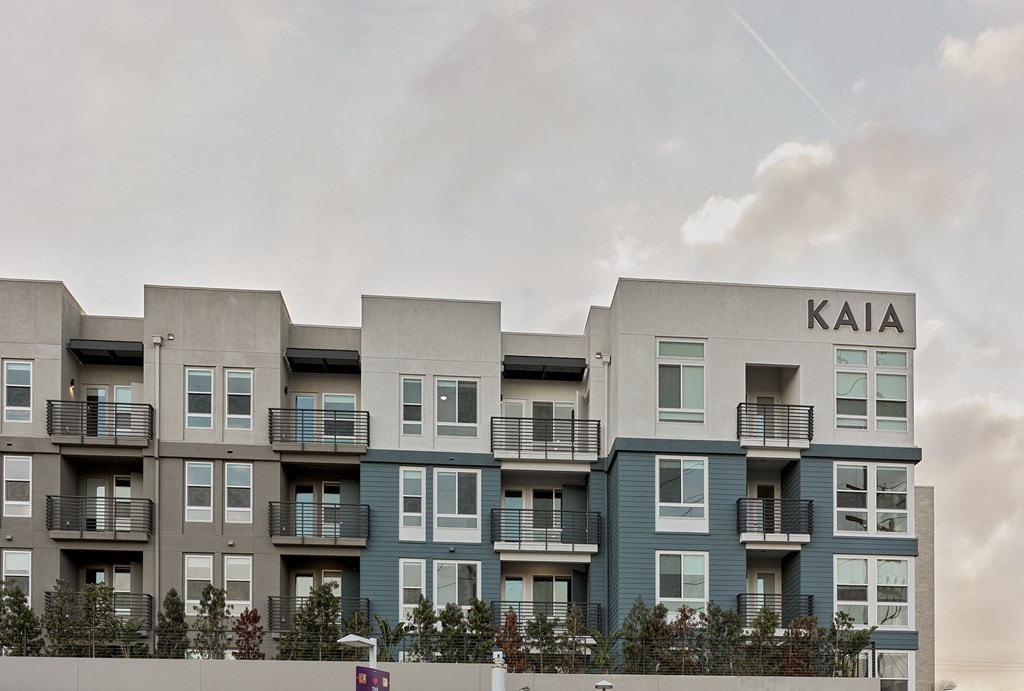 a row of apartment buildings with balconies and a cloudy sky