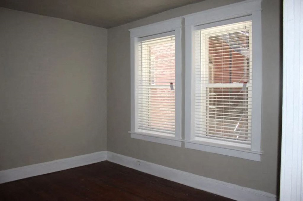 a room with two windows and a wooden floor