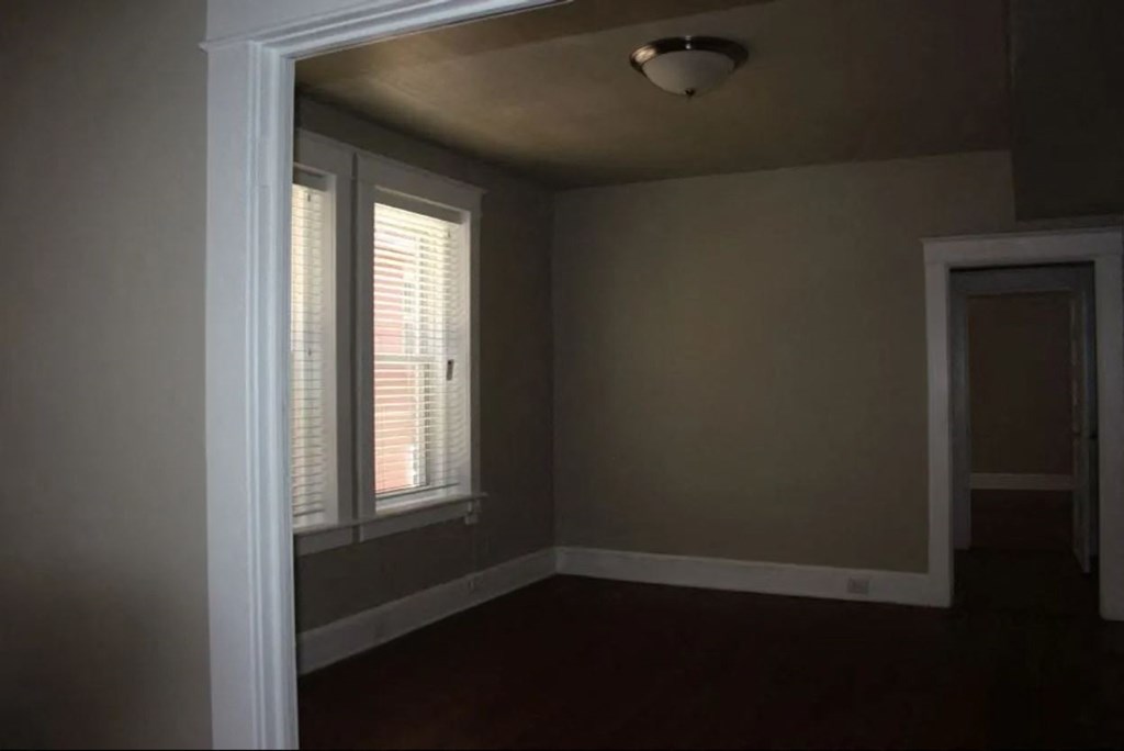 an empty room with a window and a door