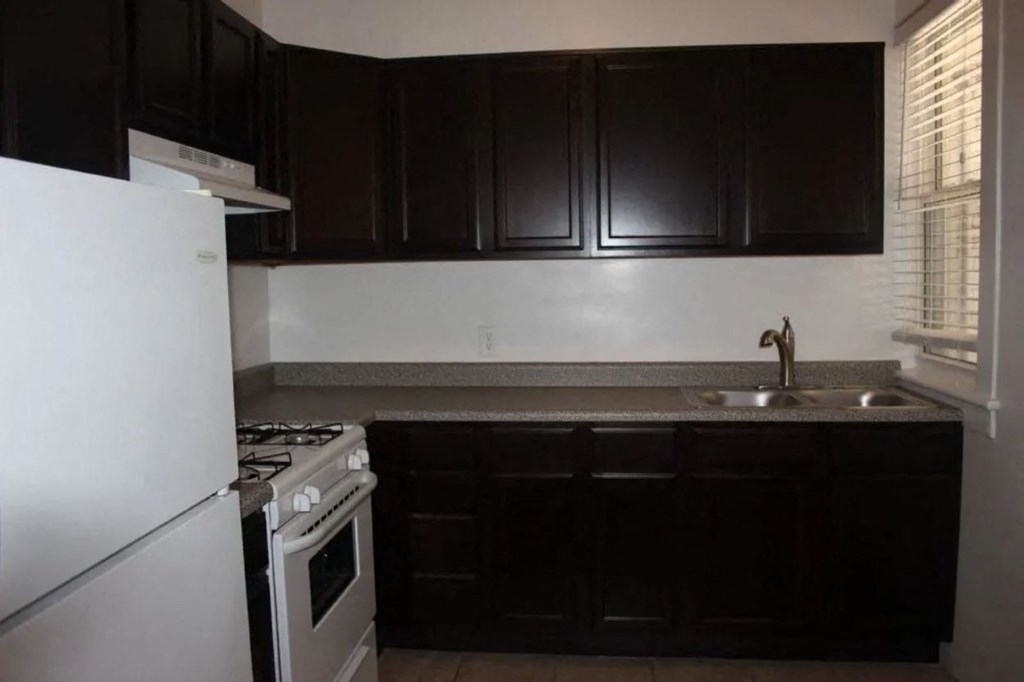 a kitchen with a stove and a sink and a refrigerator