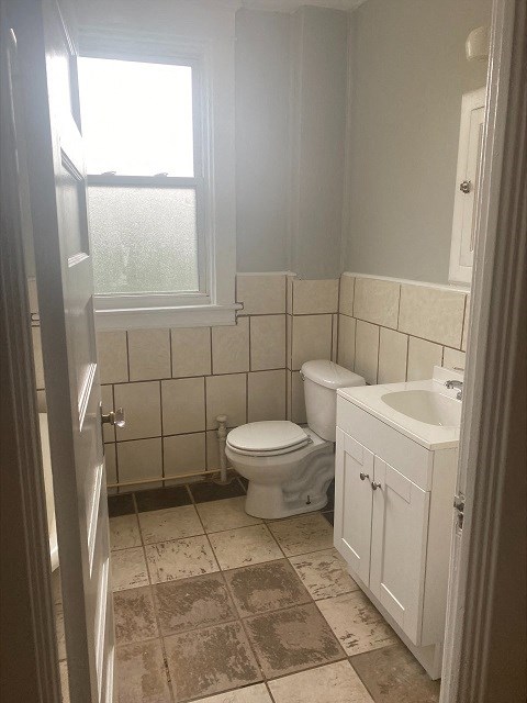 a white bathroom with a toilet and a sink