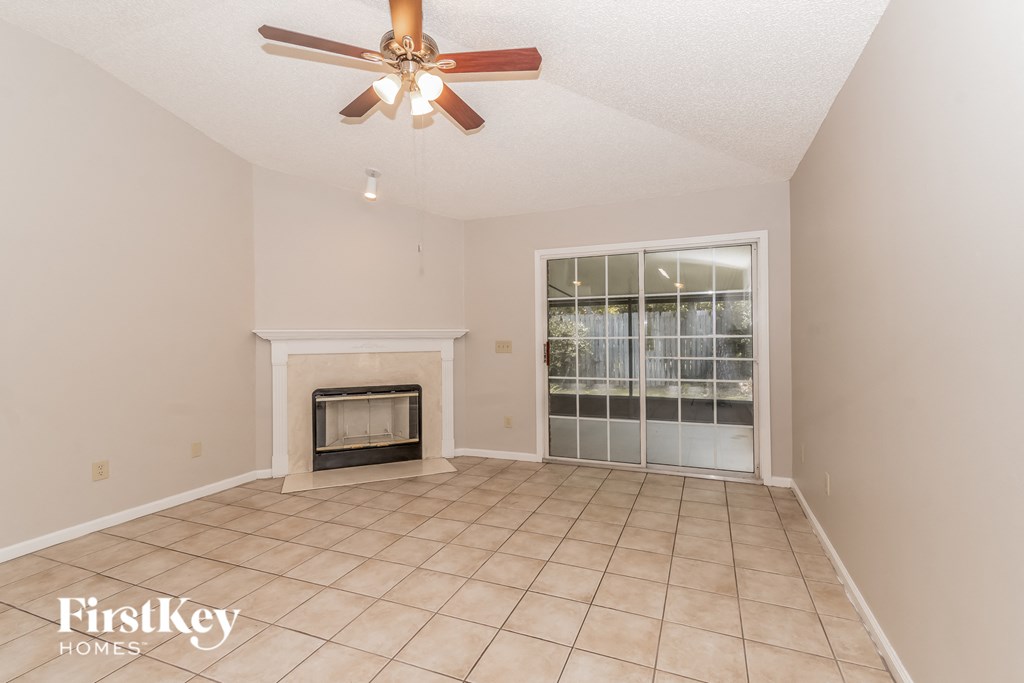 a living room with a fireplace and a ceiling fan