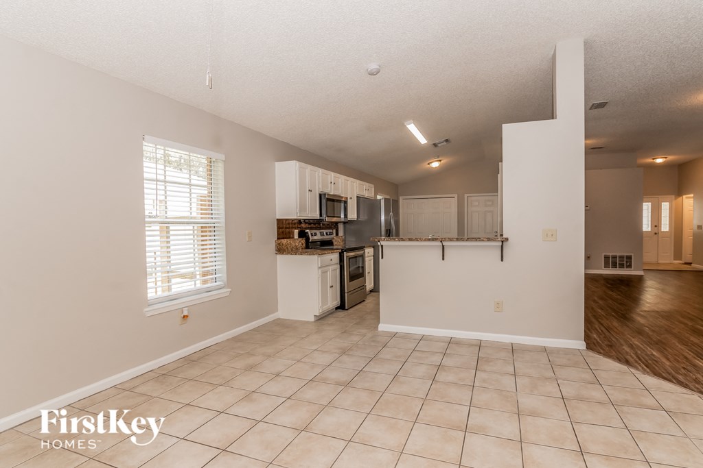 the living room and kitchen of an empty house