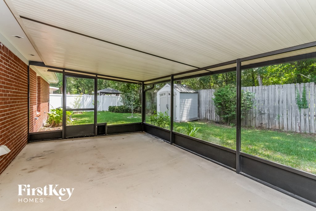 an empty patio in a backyard with large glass windows