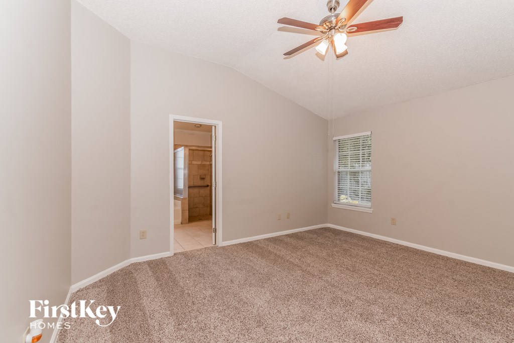 a bedroom with a carpeted floor and a ceiling fan