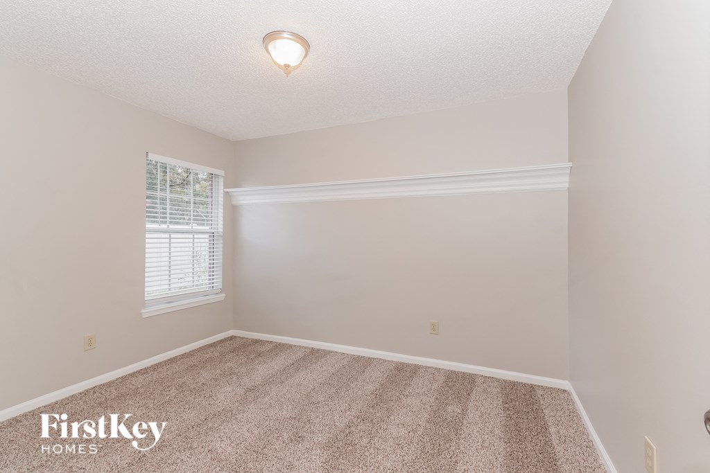 a bedroom with a carpeted floor and a window