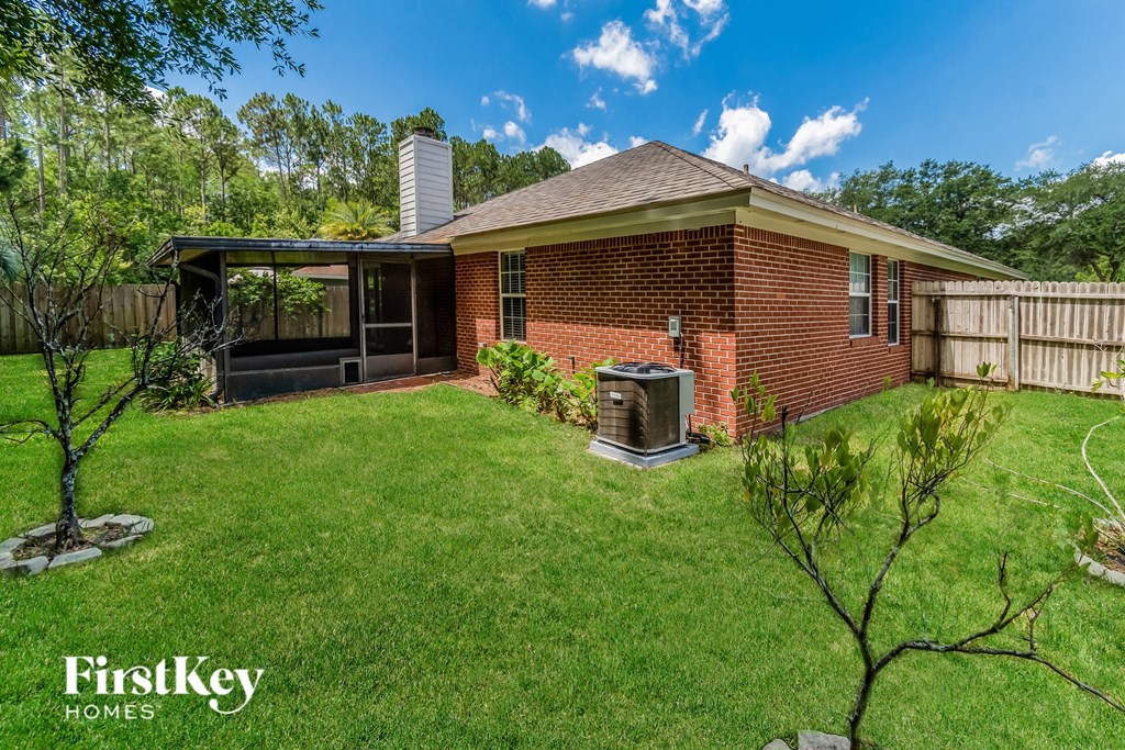 a backyard with a grill and a brick house