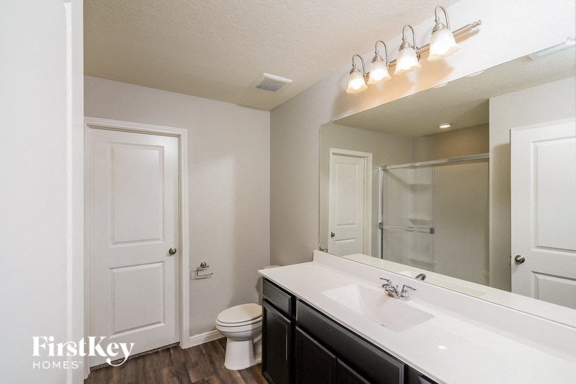 a bathroom with a large mirror and a sink and a toilet