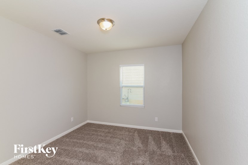 a bedroom with a carpeted floor and a window