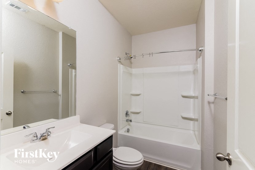 a bathroom with a shower and a sink and a mirror