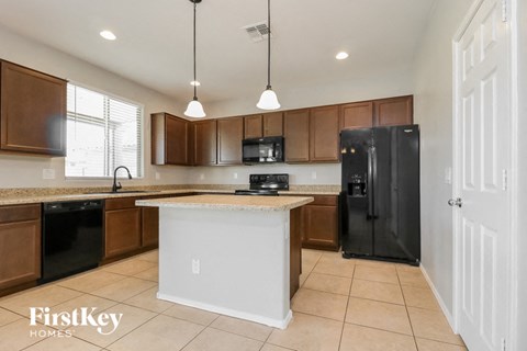 a kitchen with a black refrigerator and a counter top