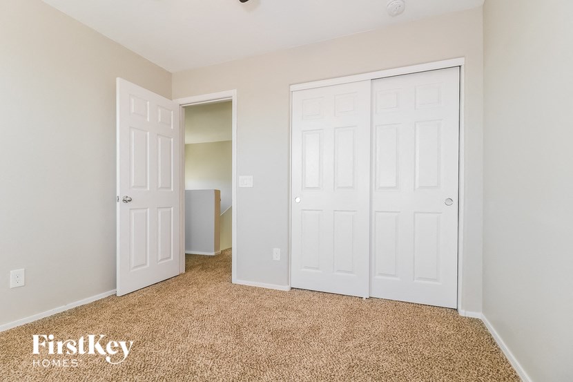 a bedroom with two closets and a door to a closet