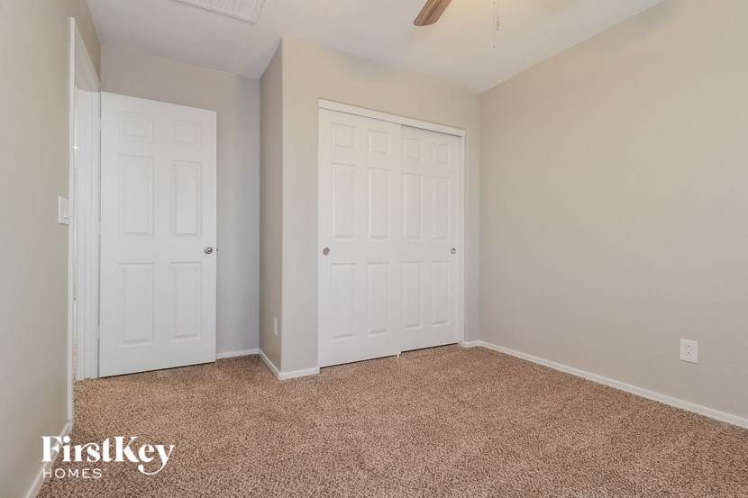 a bedroom with two closets and a carpeted floor