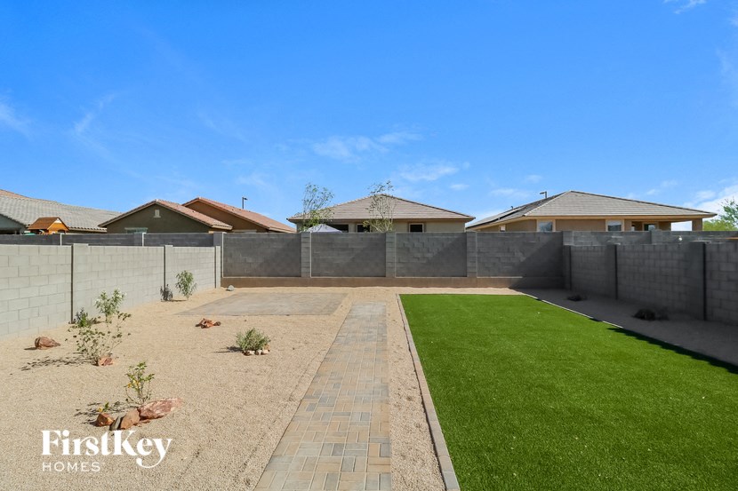 a backyard with a grass lawn and a fence