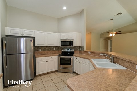 a large kitchen with stainless steel appliances and white cabinets