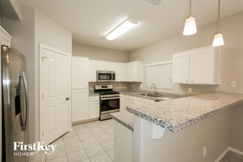 A kitchen with granite countertops and stainless steel appliances.